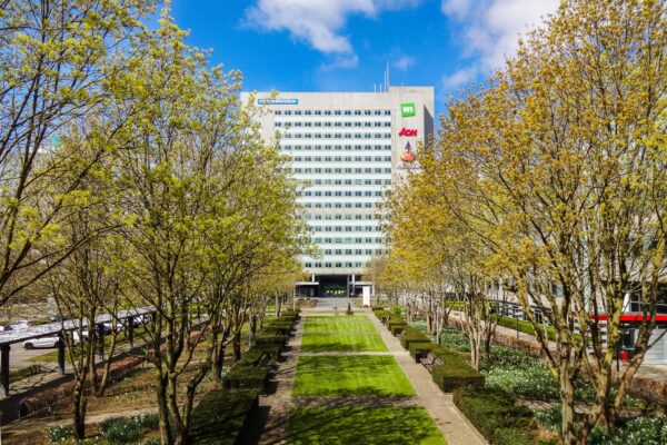 Kantoorgebouw aan de Winthontlaan in Utrecht met een groene tuin en bomen in lente-kleuren op de voorgrond.