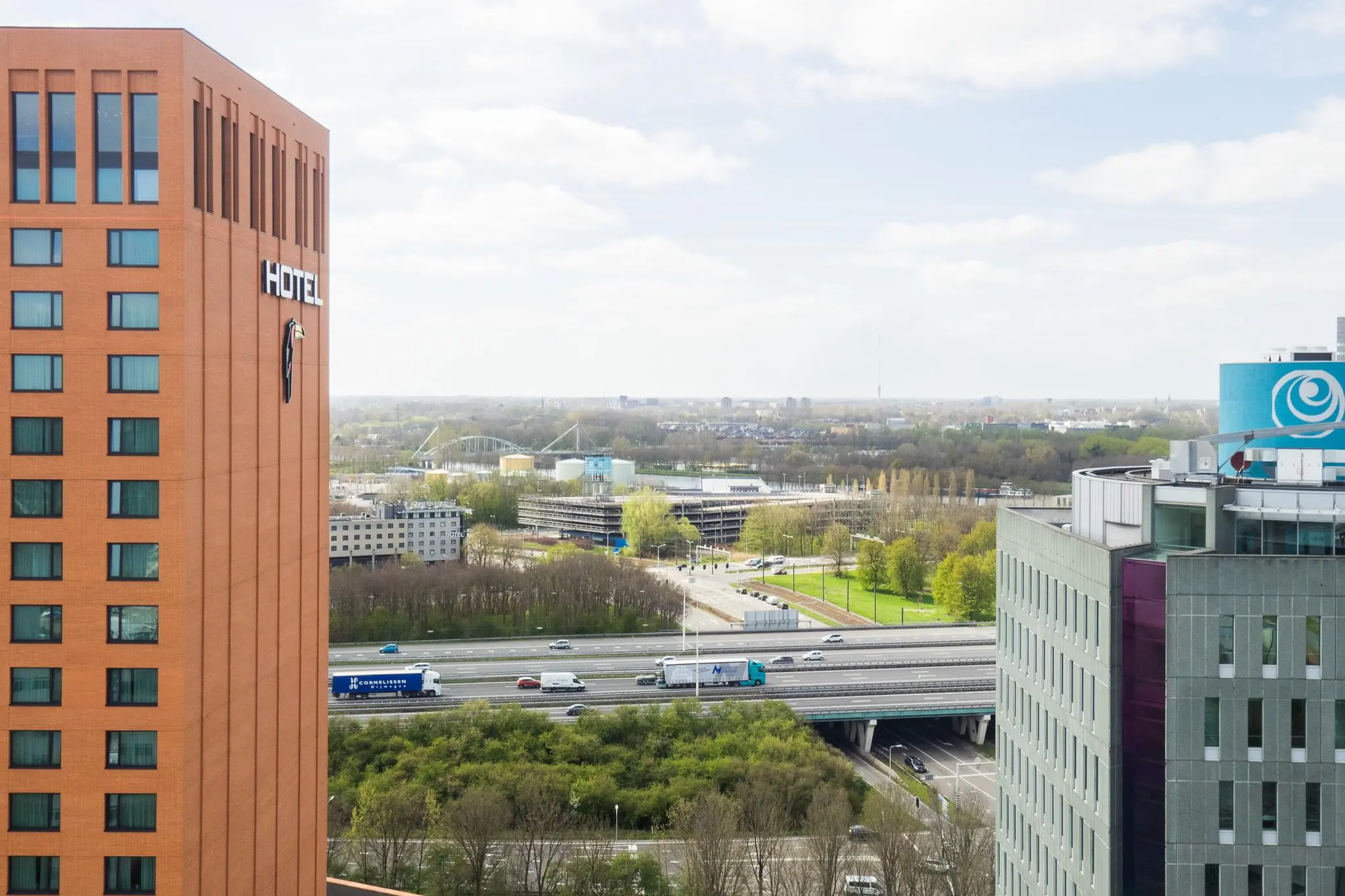Uitzicht op de Winthontlaan in Utrecht met een rood hotelgebouw, kantoren en de snelweg A12 op de voorgrond.