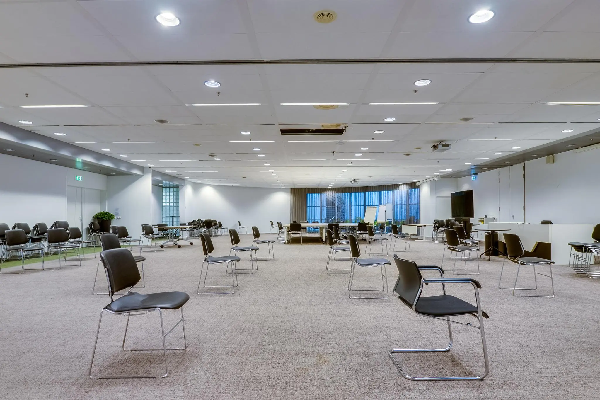 Ruime, modern ingerichte vergaderruimte aan de Winthontlaan met losse stoelen en tafels op afstand opgesteld.