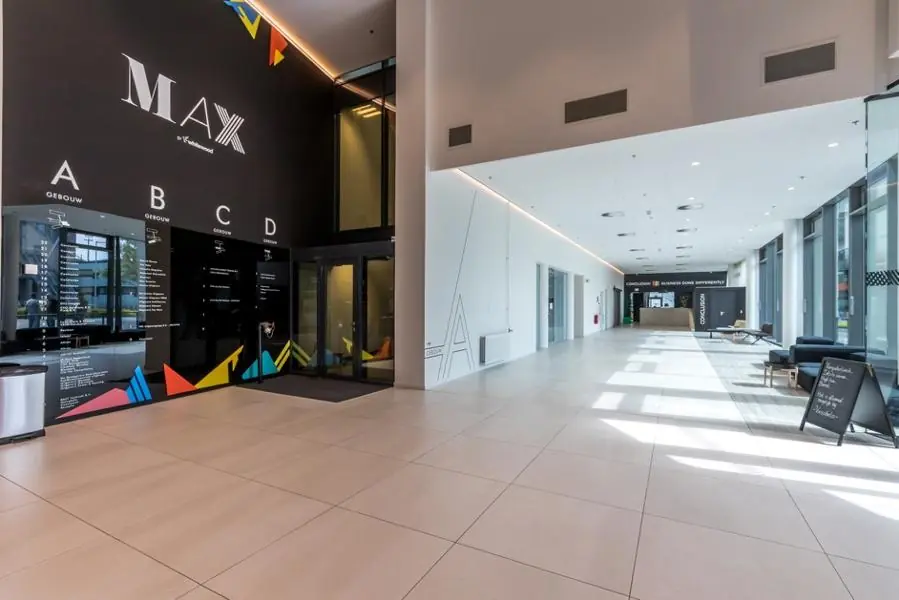 Moderne en lichte ontvangsthal van het kantoorgebouw MAX op het Herculesplein met bewegwijzering naar gebouwen A t/m D.