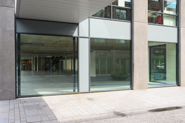 Moderne glazen gevel van een leegstaand winkel- of kantoorpand aan de Haastrechtstraat.