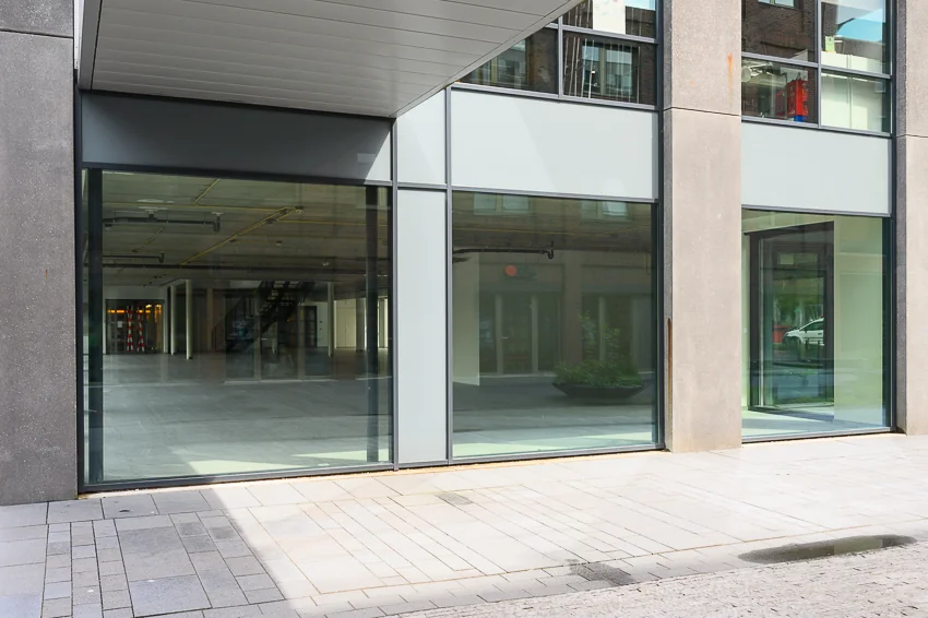 Moderne glazen gevel van een leegstaand winkel- of kantoorpand aan de Haastrechtstraat.