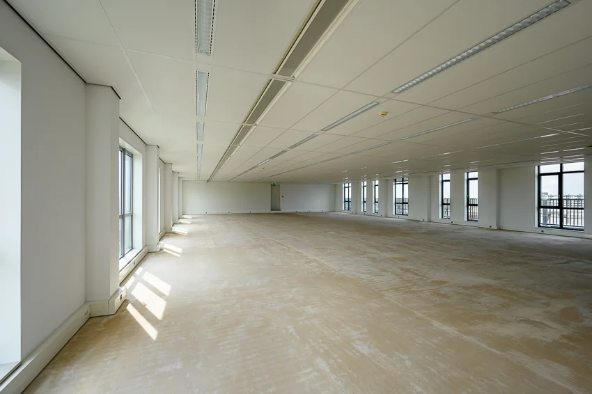 Leeg en ruim kantoorpand aan de Haastrechtstraat met grote ramen en systeemplafond.