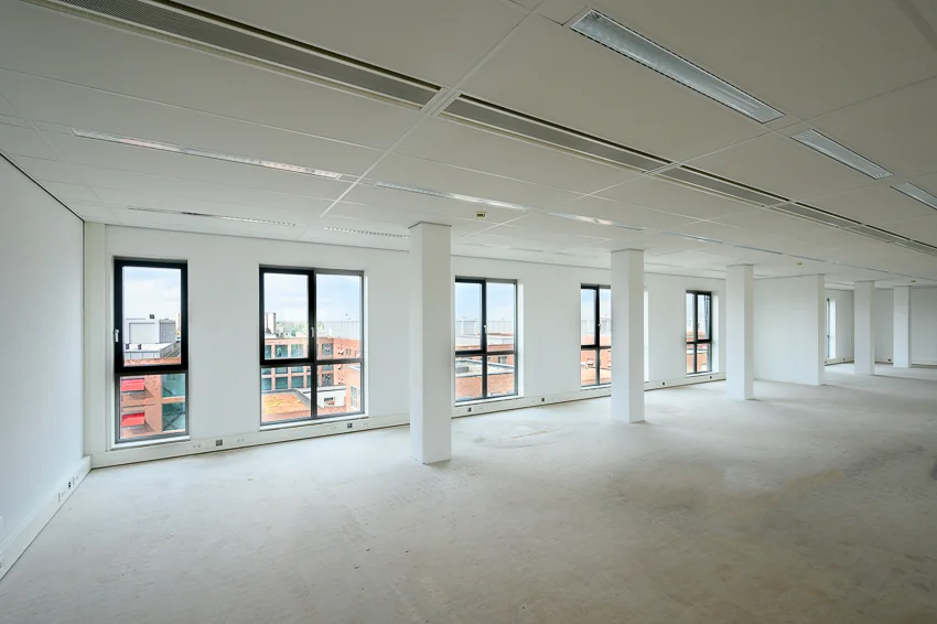 Leeg kantoorpand aan de Haastrechtstraat met grote ramen en witte muren.