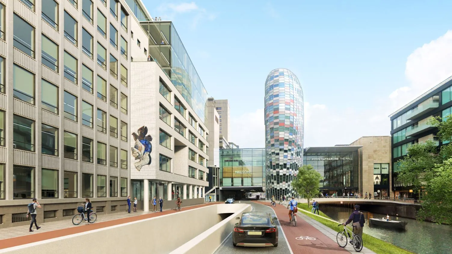 Moderne stadsstraat langs de Catharijnesingel in Utrecht met fietsers, wandelaars, een auto en het winkelcentrum Hoog Catharijne op de achtergrond.