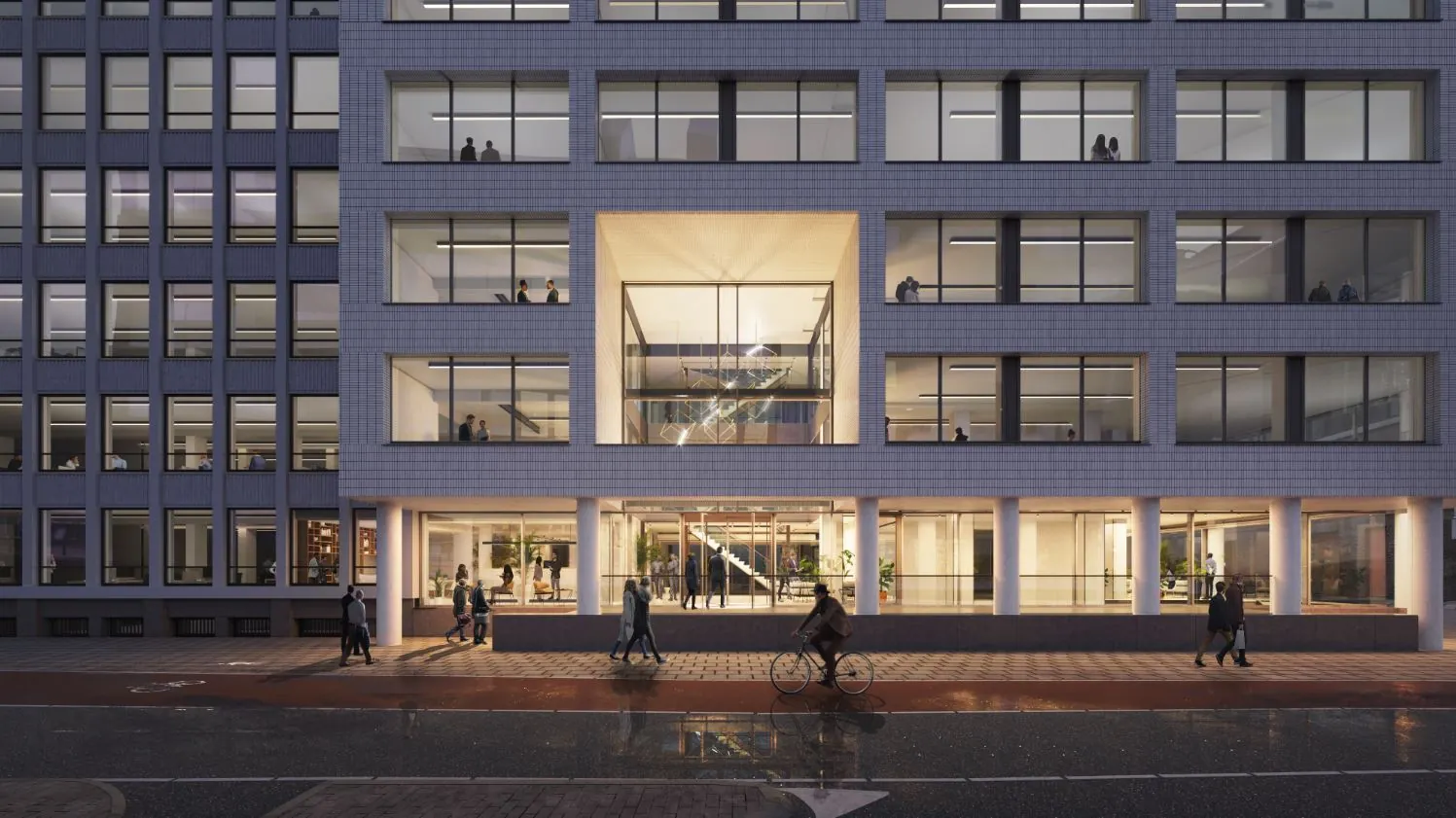 Avondzicht op de moderne gevel van het kantoorgebouw aan de Catharijnesingel met verlichte entree en passerende voetgangers en fietser.