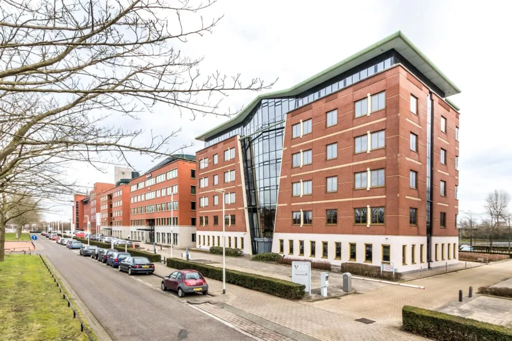 Kantoorgebouw aan de Lichtenauerlaan in Rotterdam met roodbruine gevel en moderne glazen entree.