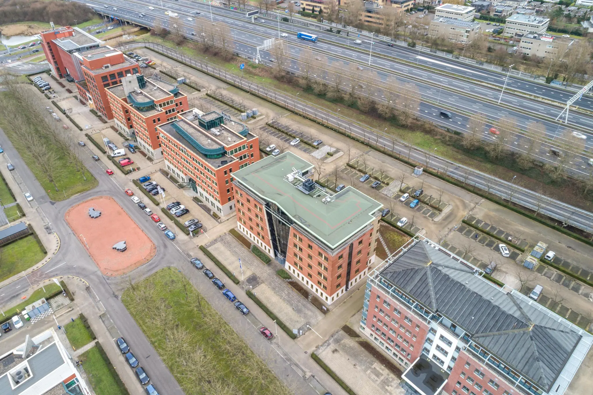 Luchtfoto van kantoorgebouwen aan de Lichtenauerlaan in Rotterdam, gelegen naast een snelweg.