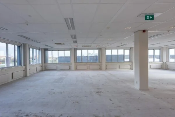 Leeg, ruim kantoorpand met grote ramen en systeemplafond in gebouw Donk.