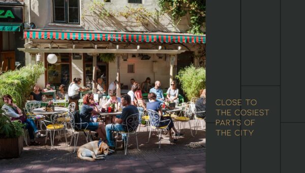 Gezellige drukte op het zonovergoten terras van café Flinck aan de Vijzelgracht, met mensen die genieten van eten en drinken.