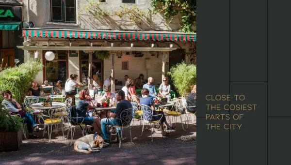 Gezellige drukte op het zonovergoten terras van café Flinck aan de Vijzelgracht, met mensen die genieten van eten en drinken.