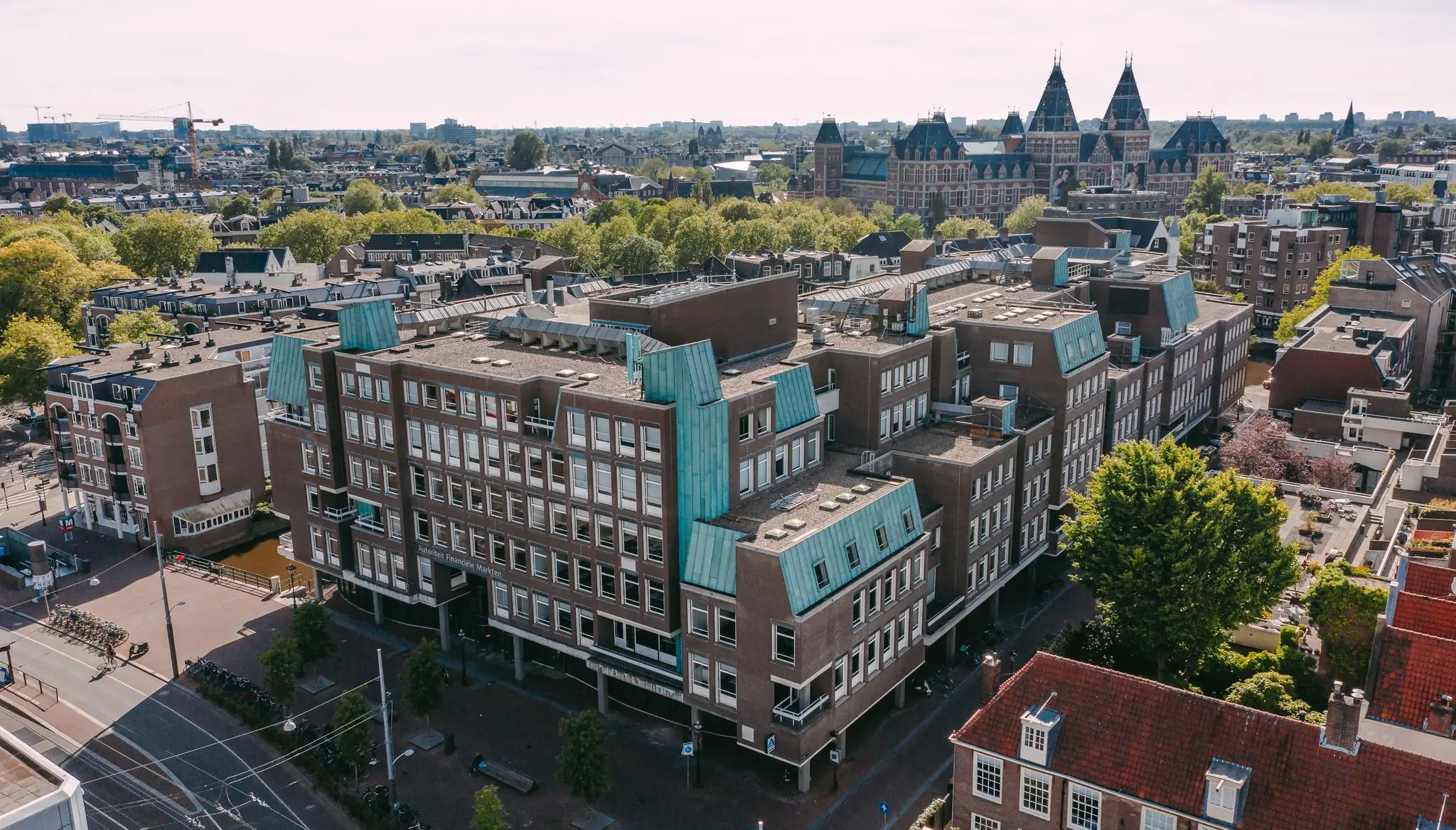 Luchtfoto van een groot kantoorgebouw aan de Vijzelgracht in Amsterdam, met het Rijksmuseum op de achtergrond.