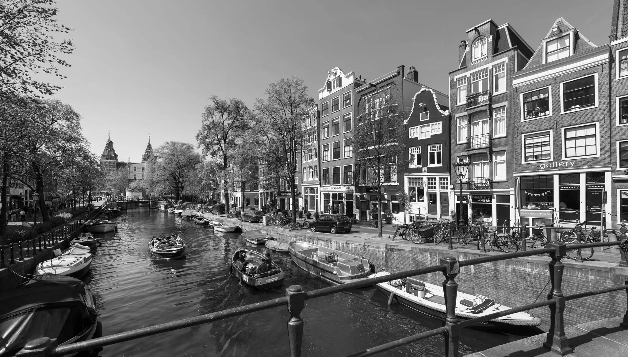 Zwart-witfoto van de Vijzelgracht in Amsterdam met boten op het water en grachtenpanden langs de kade.
