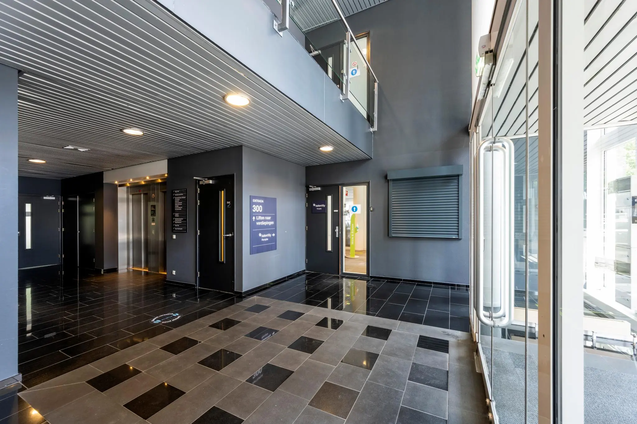 Moderne entreehal van een kantoorpand met lift, glazen deuren en bewegwijzering naar verdieping 300.