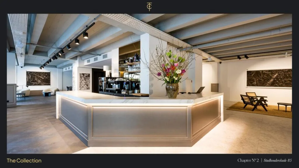 Moderne, stijlvol ingerichte lobby aan de Stadhouderskade 85 met marmeren balie, bloementoog en kunst aan de muren.