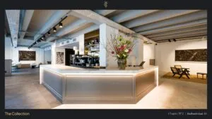 Moderne, stijlvol ingerichte lobby aan de Stadhouderskade 85 met marmeren balie, bloementoog en kunst aan de muren.