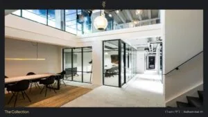 Modern kantoorinterieur aan de Stadhouderskade 85 met glazen vergaderruimtes, een grote houten vergadertafel en strakke, industriële details.