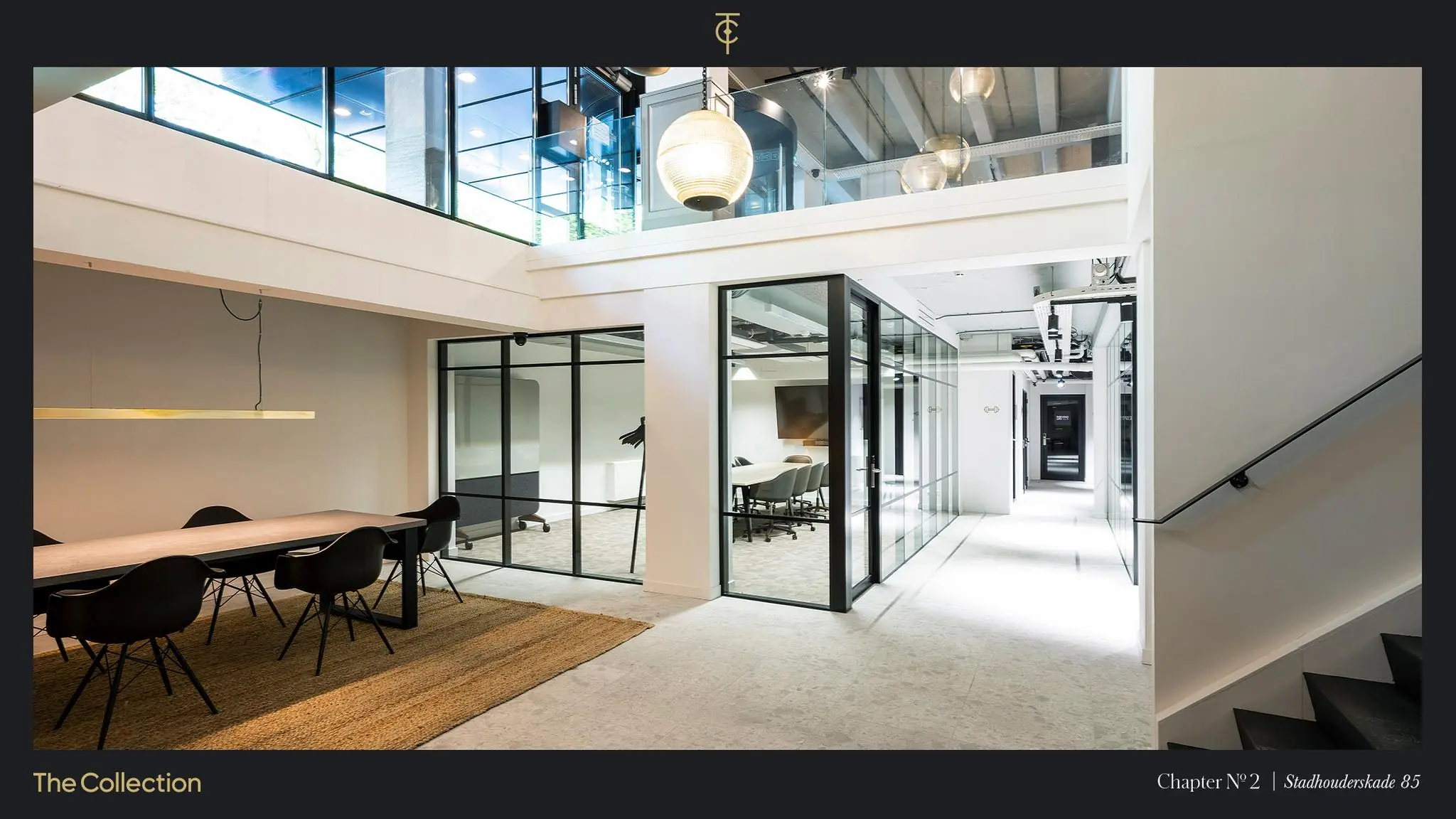 Modern kantoorinterieur aan de Stadhouderskade 85 met glazen vergaderruimtes, een grote houten vergadertafel en strakke, industriële details.