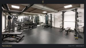 Moderne fitnessruimte in Stadhouderskade 85 met halters, krachttoestellen en trainingsbanken.