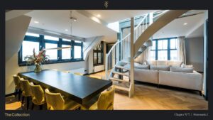 Stijlvol modern interieur op Westermarkt 2 met eet- en zithoek, houten visgraatvloer en een witte wenteltrap.