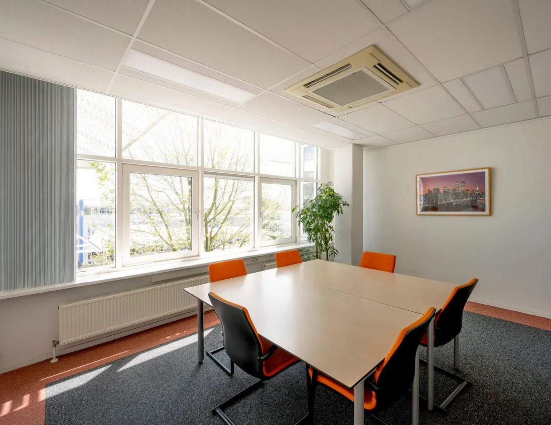 Vergaderruimte met zes stoelen, een grote tafel, veel daglicht en een schilderij aan de muur aan de Gyroscoopweg.