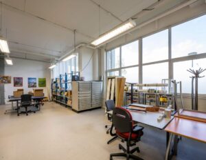 Lichte en ruime werkplaats aan de Gyroscoopweg met werktafels, opbergkasten en technische apparatuur.