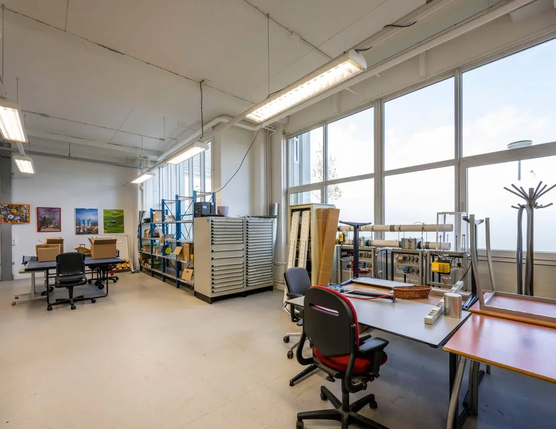Lichte en ruime werkplaats aan de Gyroscoopweg met werktafels, opbergkasten en technische apparatuur.