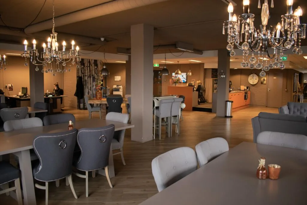 Moderne en sfeervolle ontvangstruimte aan de Zaagmolenlaan met luxe kroonluchters, zitgedeelte en ontvangstbalie.