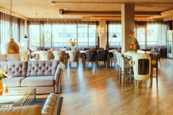 Stijlvol ingerichte lounge aan de Zaagmolenlaan met comfortabele zitplaatsen, grote ramen en een bar gemaakt van een klassieke tractorneus.