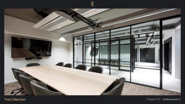 Moderne vergaderruimte met glazen wanden, groot scherm en een houten tafel op Stadhouderskade 85.