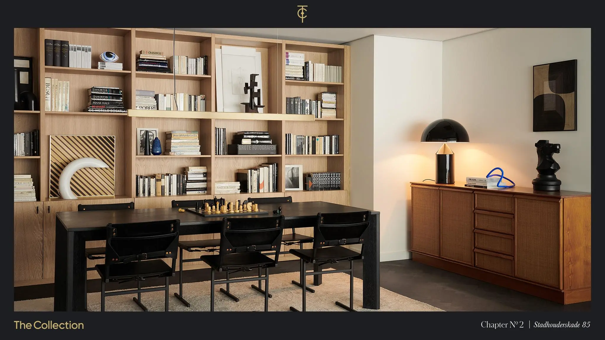 Stijlvol ingerichte woonruimte aan de Stadhouderskade met een wandkast vol boeken, een zwarte eettafel met schaakbord en een retro dressoir met moderne kunstobjecten.