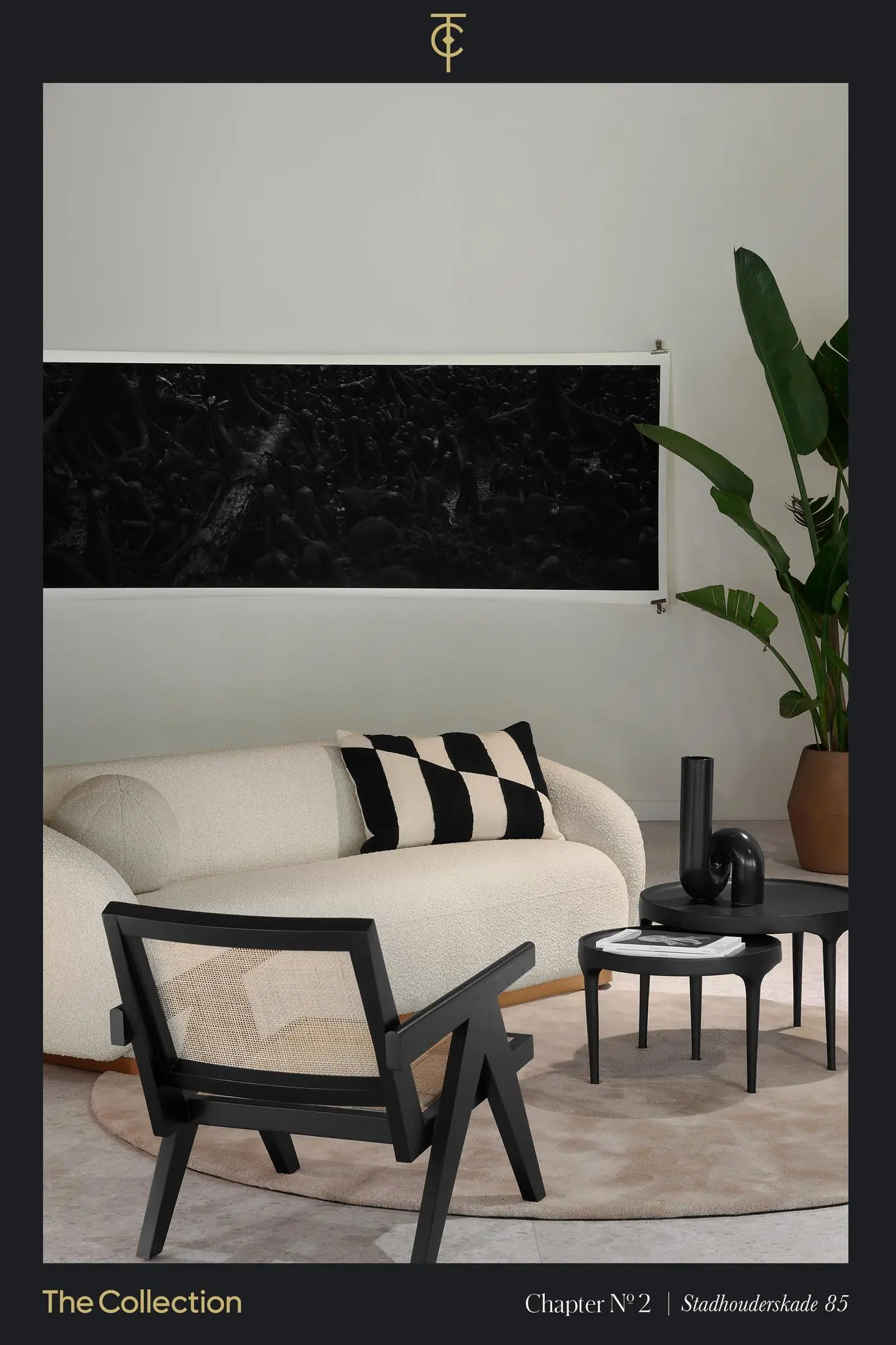 Modern ingerichte zithoek met een crèmekleurige bank, zwarte accenten en een grote groene plant, gepresenteerd in The Collection op Stadhouderskade 85.