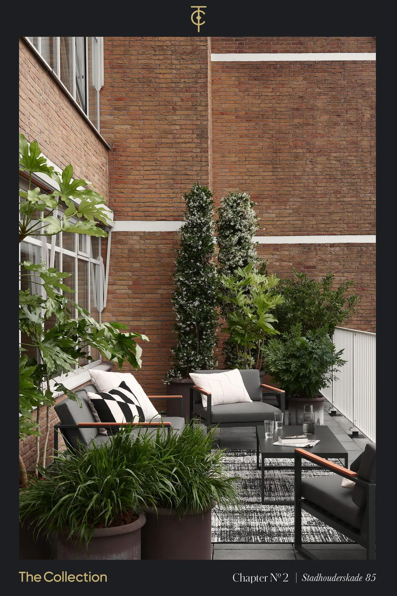 Stijlvol ingericht terras op Stadhouderskade 85 met moderne lounge meubels en weelderige planten tegen een bakstenen gevel.