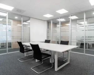 Moderne vergaderruimte met vier stoelen en een witte tafel in een kantoor aan de Hurksestraat 43 in Eindhoven.