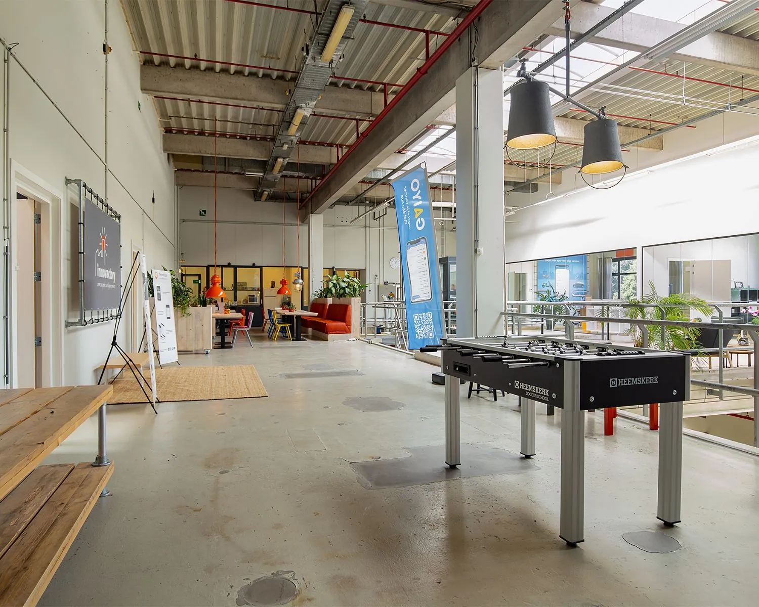 Moderne en open kantoorruimte aan de Bolderweg 2 in Almere met zithoeken, vergaderruimte en een tafelvoetbaltafel.