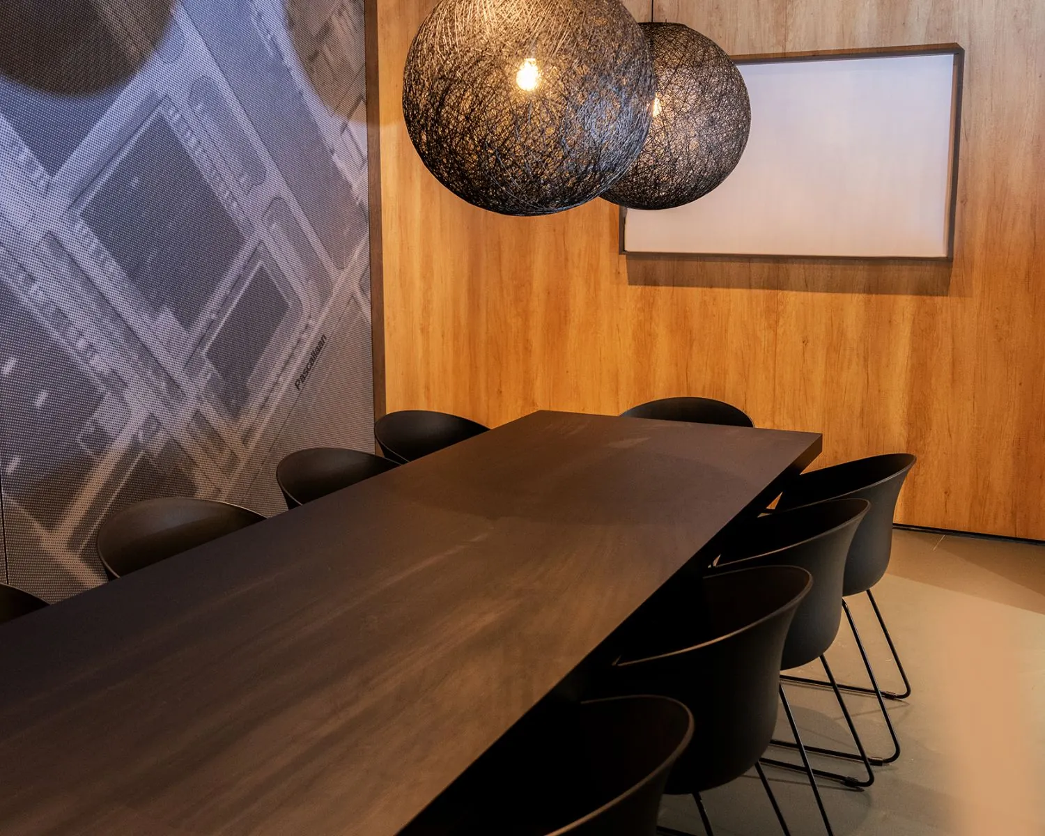 Moderne vergaderruimte aan de Pascallaan 60-78 in Lelystad met een lange zwarte tafel, zwarte stoelen en sfeervolle hanglampen.