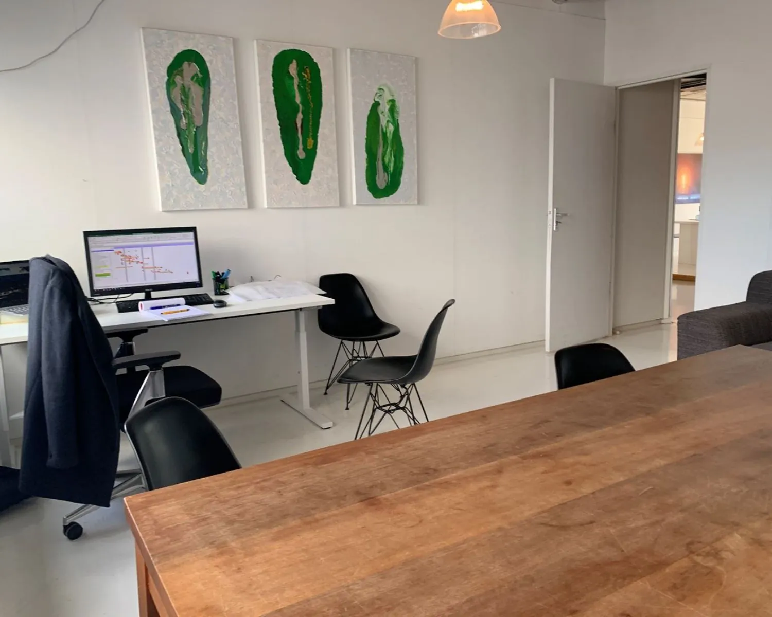 Moderne kantoorruimte aan de Anthony Fokkerweg 21 in Amsterdam met bureau, vergadertafel en opvallende wandkunst.