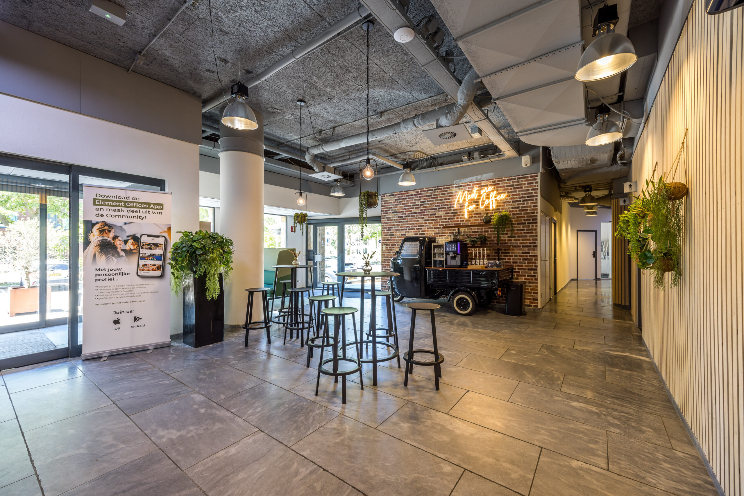 Moderne kantoorentree bij Element Offices in Utrecht met industriële inrichting en koffietafel.