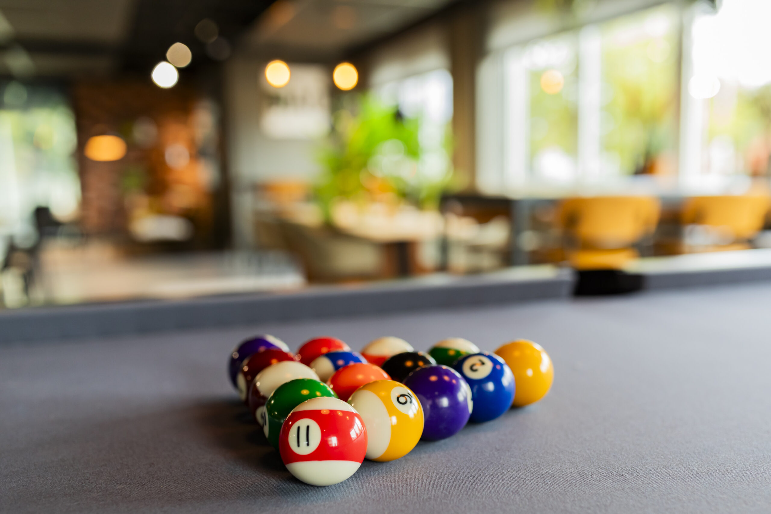 Biljartballen liggen verzameld op een biljarttafel in een sfeervolle ruimte.