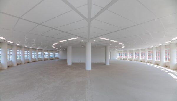 Lichte, lege kantoorruimte met ronde vorm en grote ramen aan het Wilhelminaplein.
