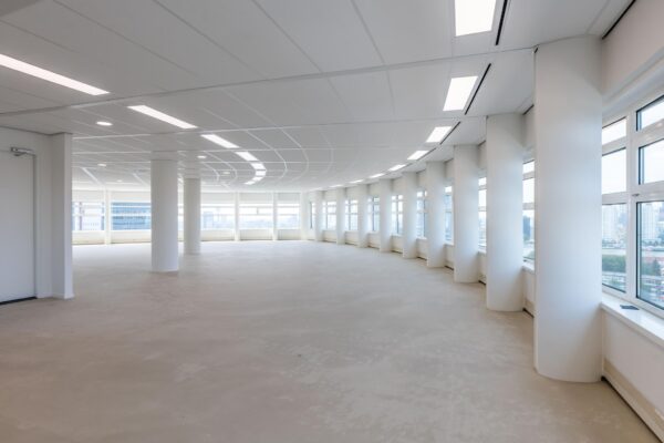 Licht en modern kantoorpand op Wilhelminaplein met grote ramen en ronde pilaren.