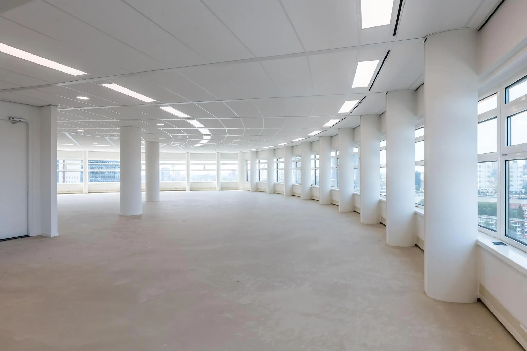 Licht en modern kantoorpand op Wilhelminaplein met grote ramen en ronde pilaren.