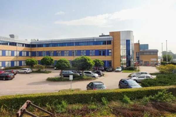 Kantoorpand aan de Kernkade met parkeerplaatsen en enkele geparkeerde auto's op de voorgrond.