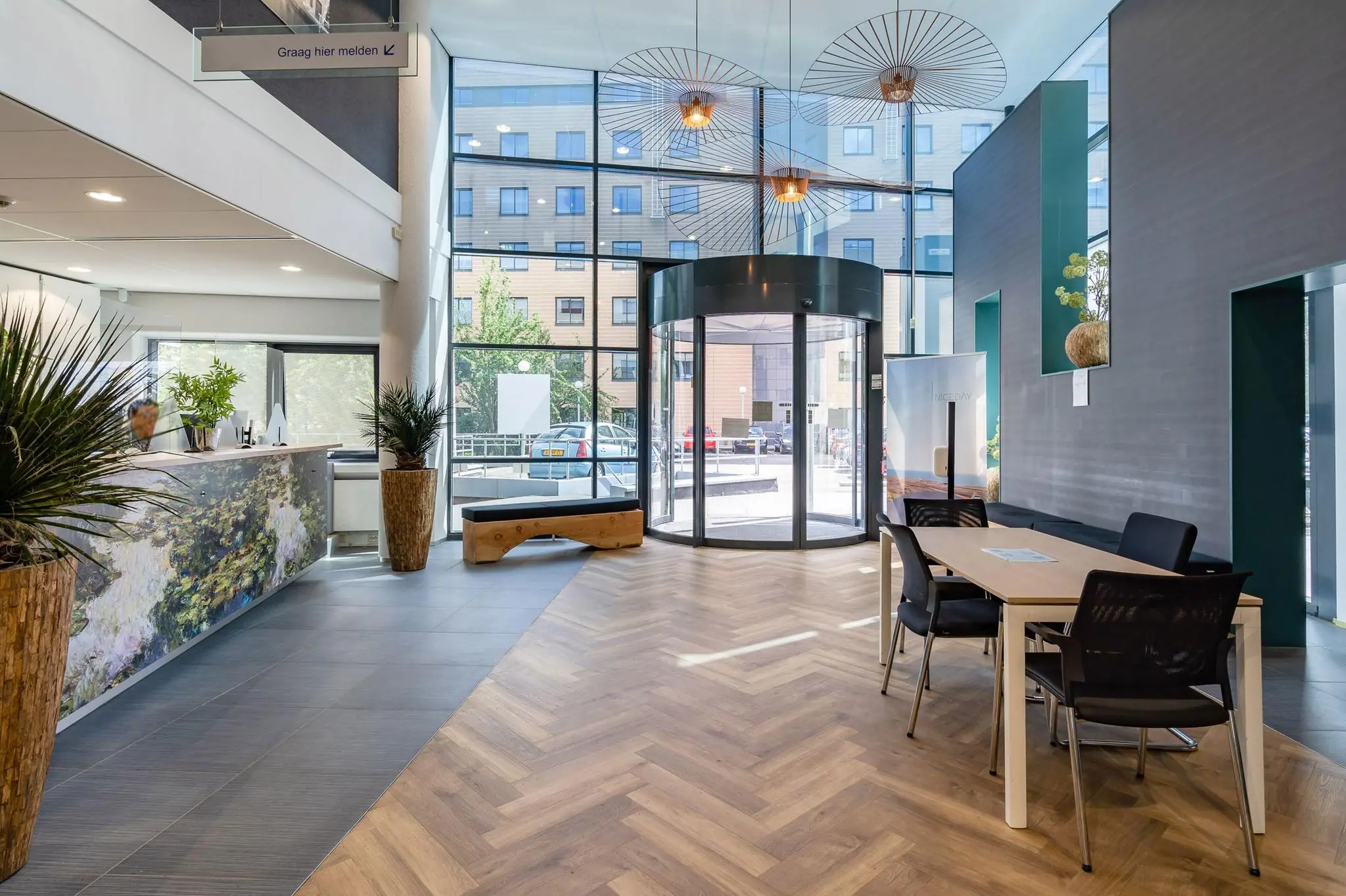 Moderne en lichte entreehal aan de Euclideslaan met balie, wachtruimte en glazen draaideur.