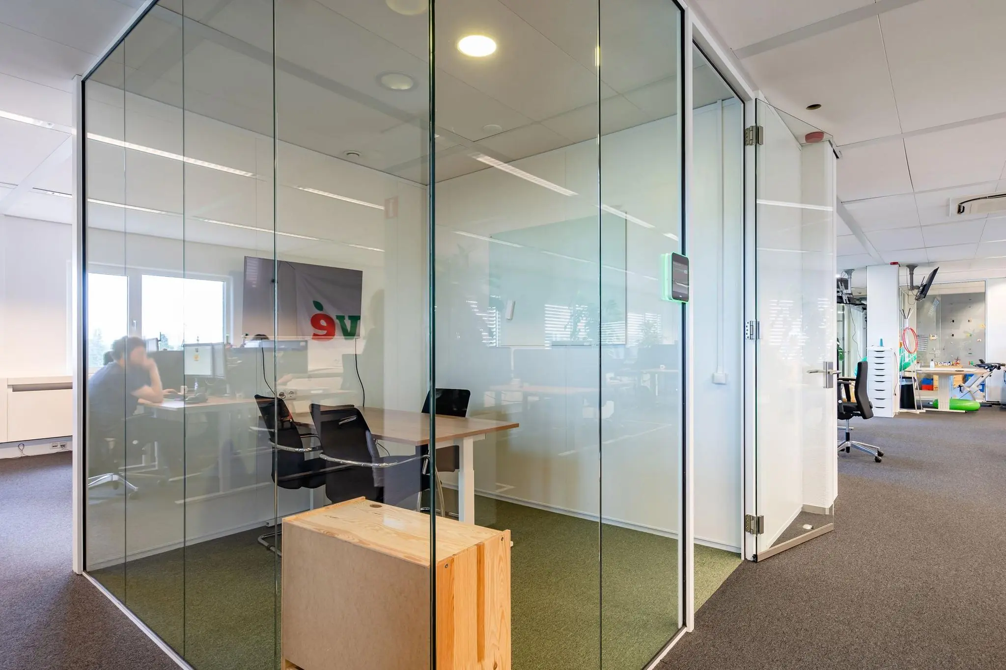 Moderne kantoortuin met glazen vergaderruimtes en werkplekken aan de Euclideslaan.