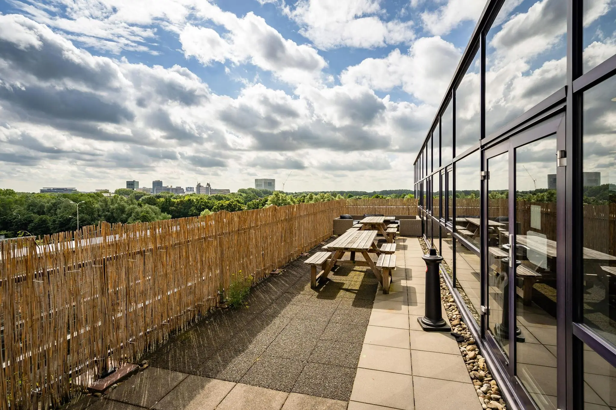Dakterras met picknicktafels en uitzicht op de skyline van Utrecht vanaf de Euclideslaan.
