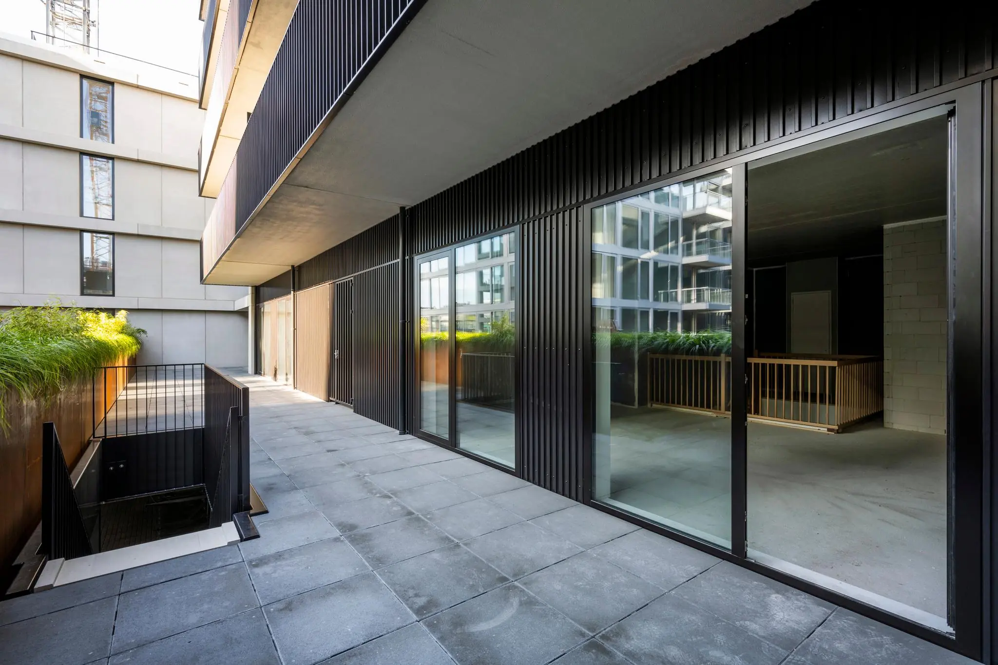Moderne buitenruimte met glazen schuifdeuren aan de Oostenburgermiddenstraat in Amsterdam.