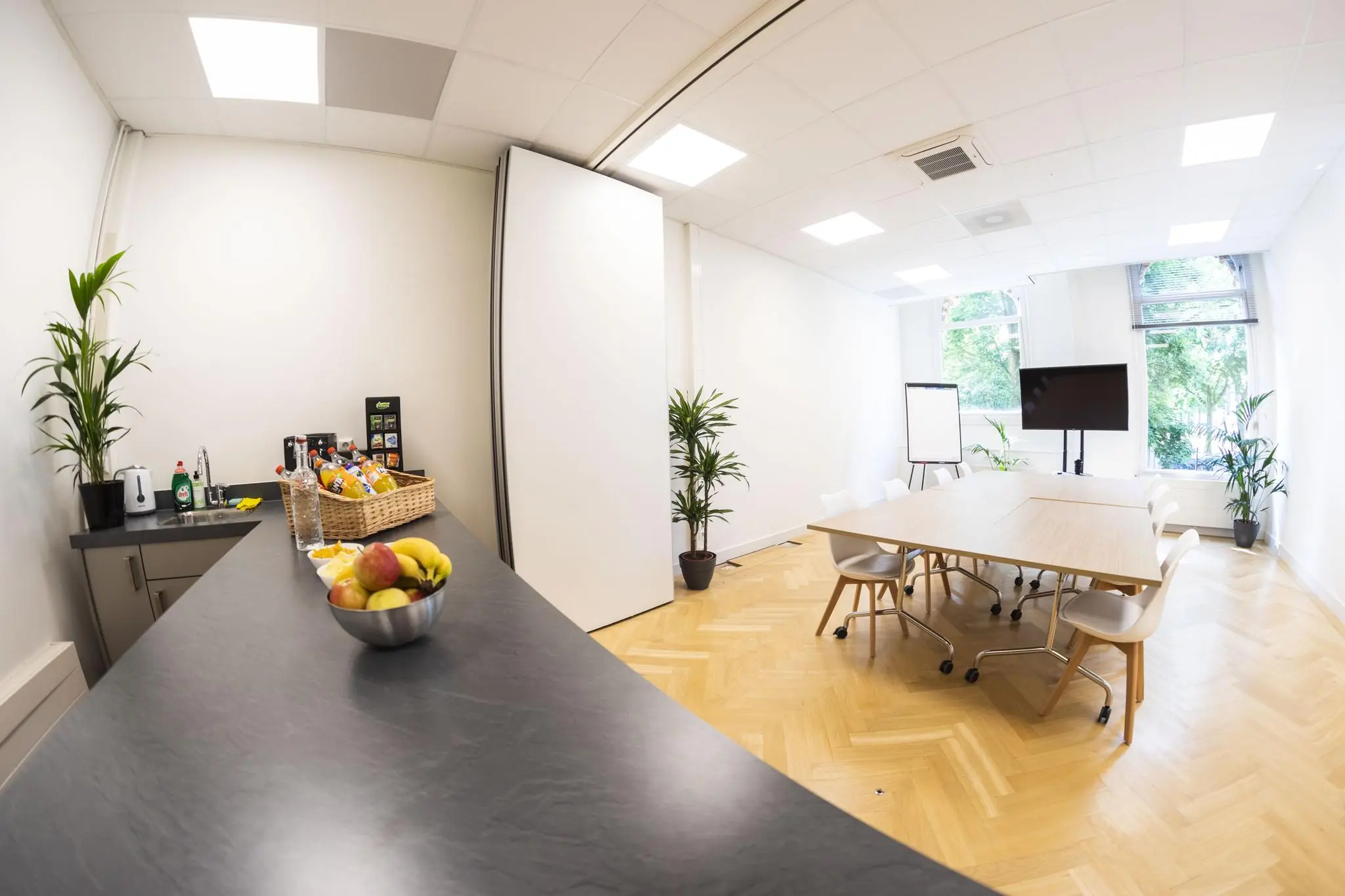 Vergaderruimte Westplein met een moderne opstelling, een presentatiehoek en een koffiecorner met fruit en drankjes.