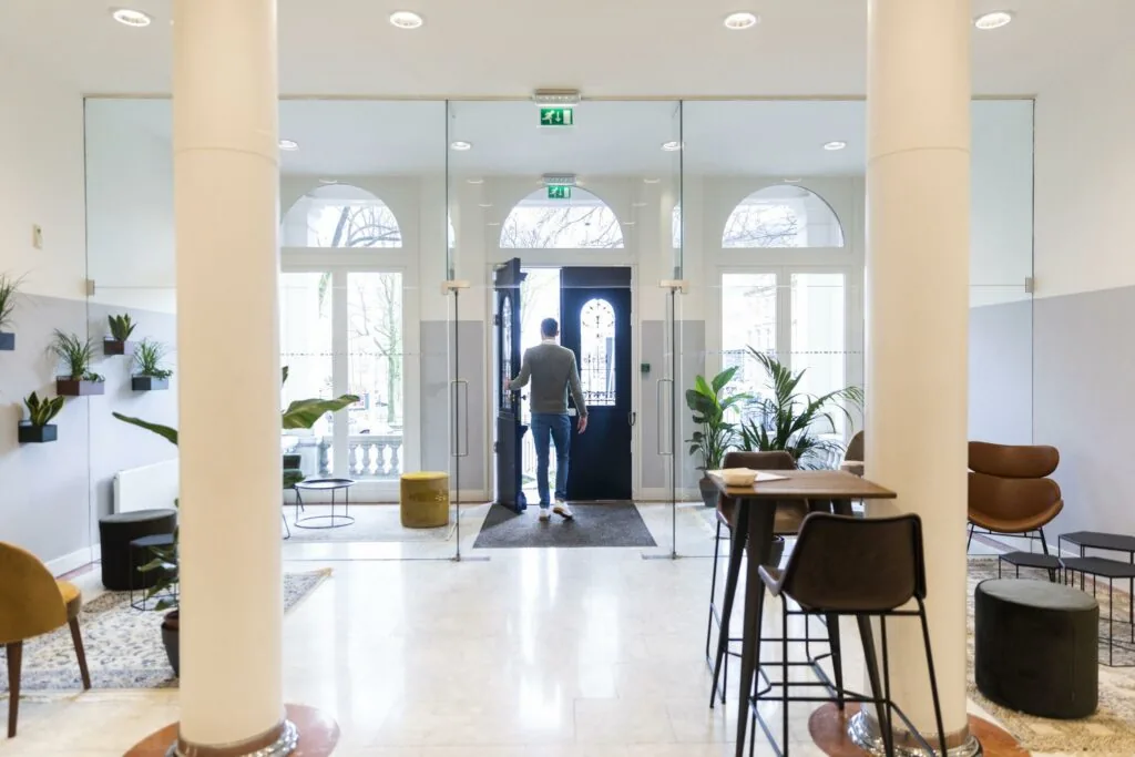 Man verlaat een modern ingericht kantoor aan het Westplein via een glazen entree.