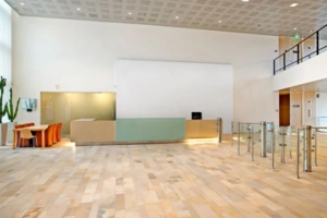 Moderne, lichte ontvangsthal aan de Tupolevlaan met balie, wachtruimte en toegangspoortjes.